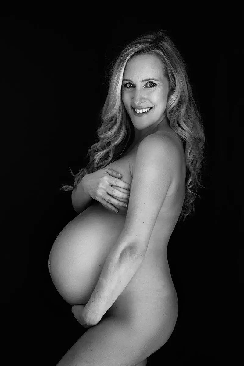 demi moore style pregnancy photo: Radiant mum-to-be smiling softly in a natural, elegant maternity portrait.