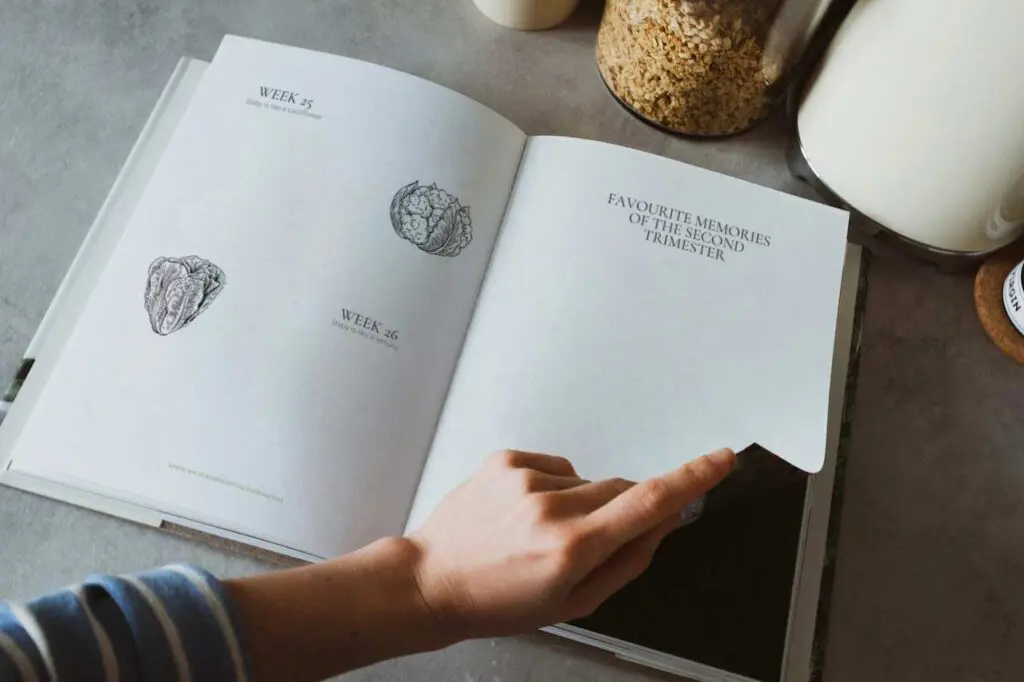 Hand of mum flipping the page of her pregnancy journal