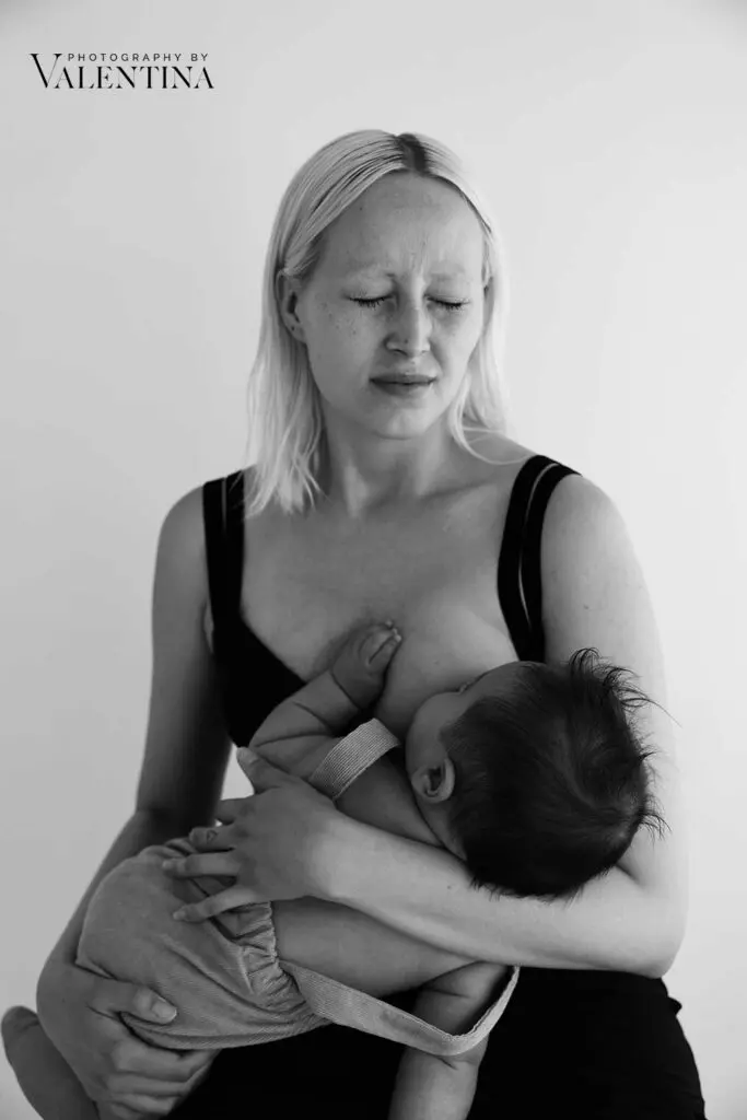 Postpartum recovery: A mother breastfeeding her baby, capturing a raw painful moment 