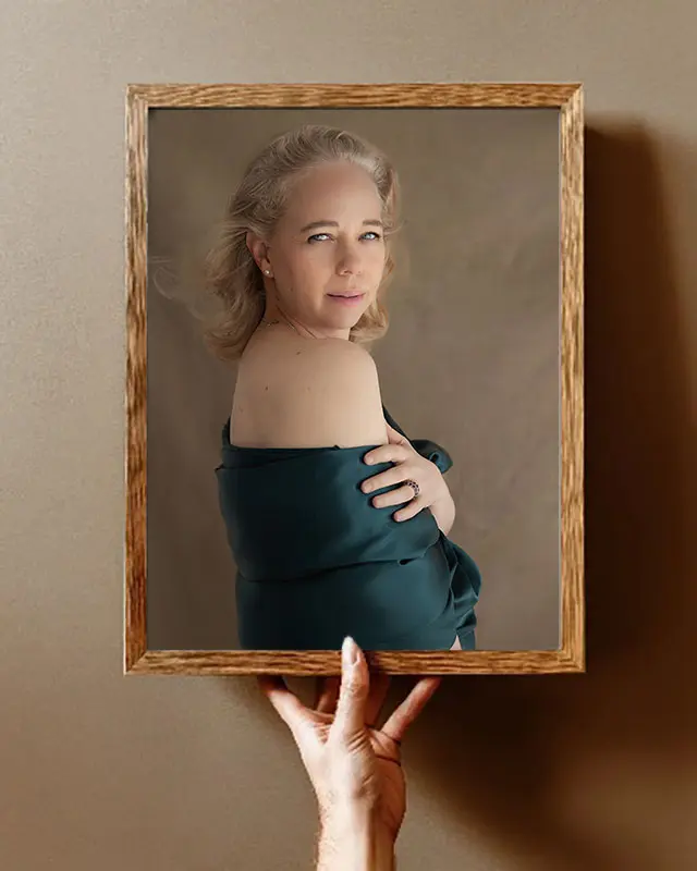 Woman holding up a framed portrait of herself, a reminder that being properly seen is different from a mirror or a selfie.