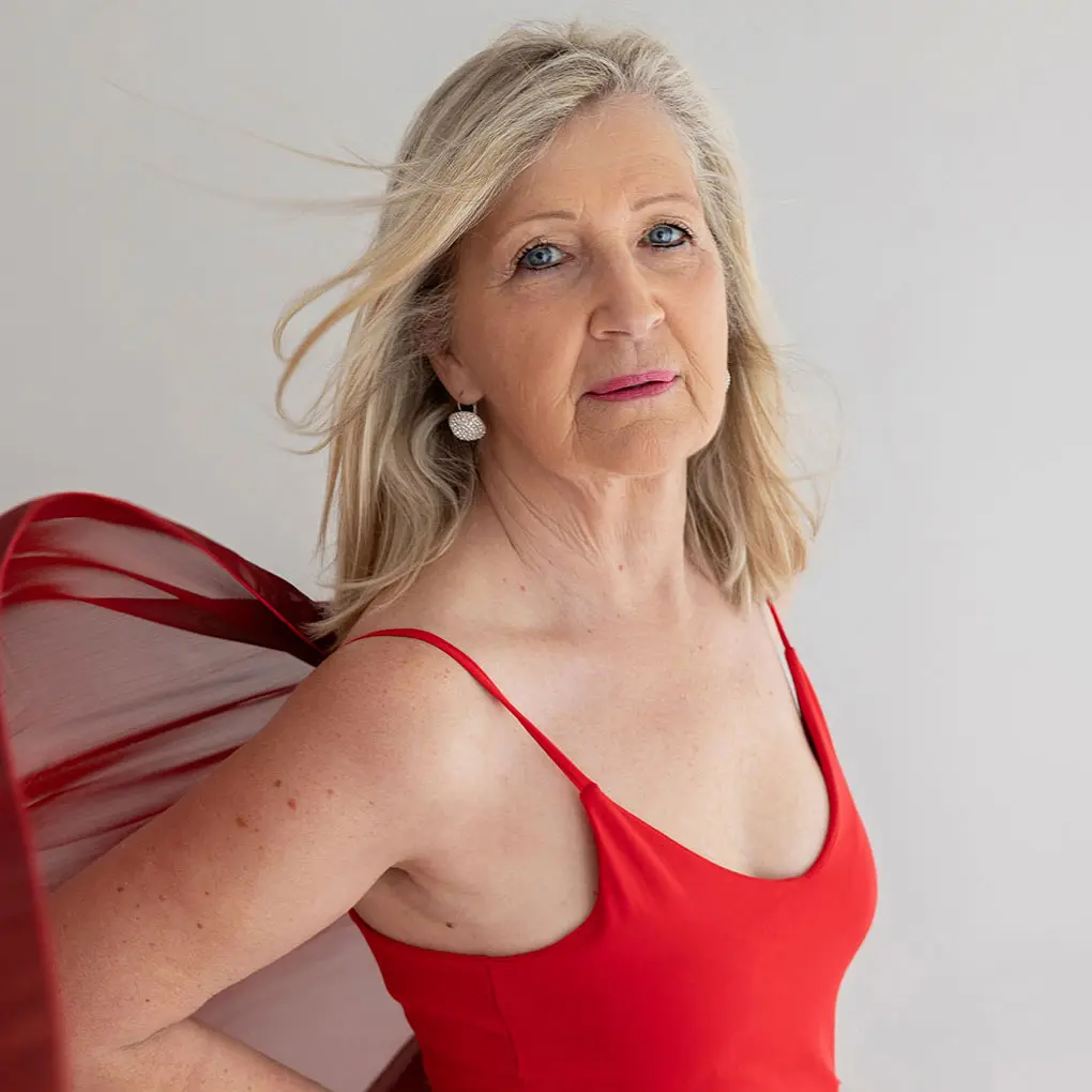 My mum in a red dress in my Twickenham studio, a portrait about body image after 40 and seeing yourself kindly