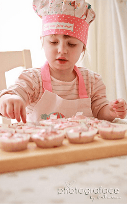 image of a little girl preparing cupcakes