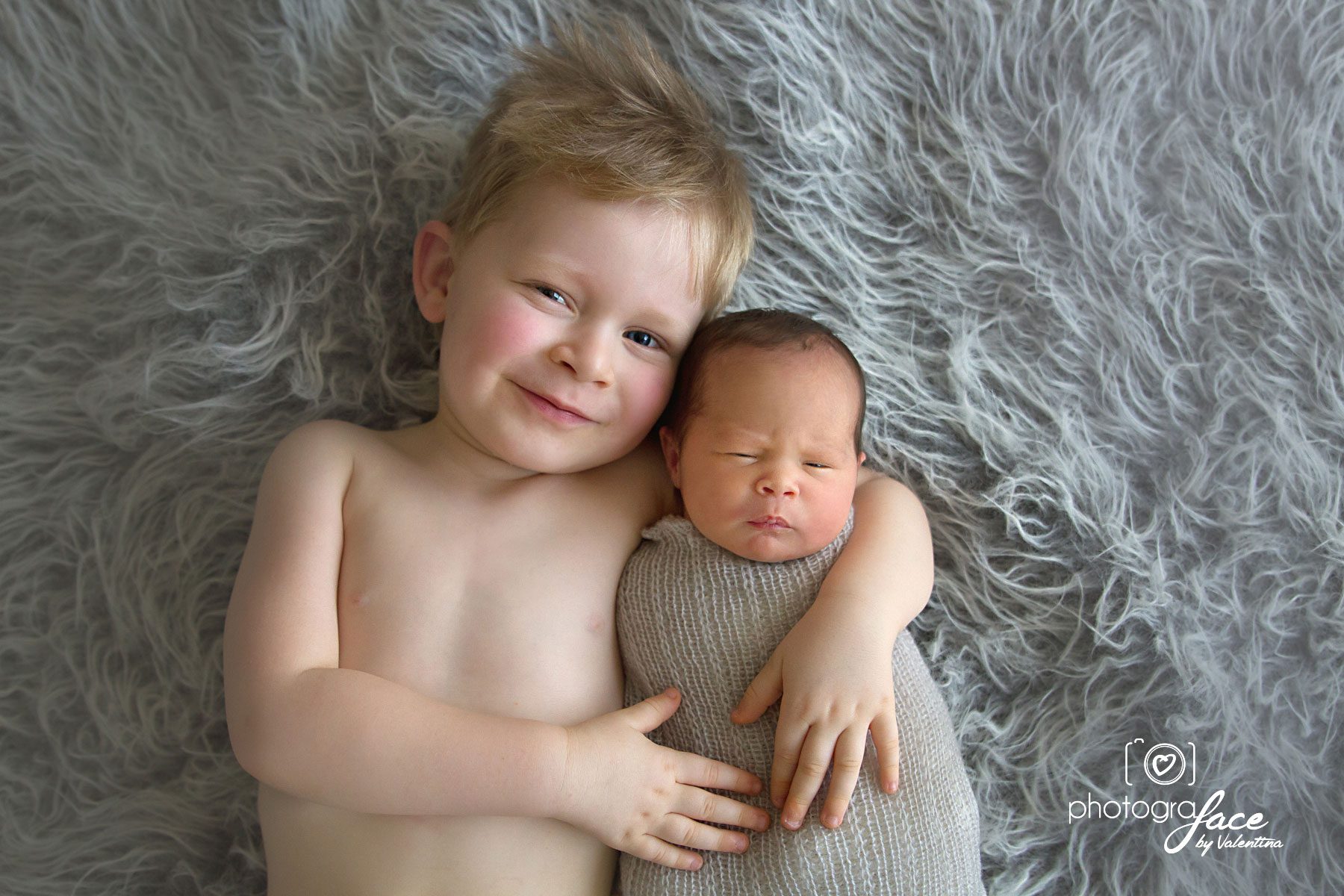 big brother holding newborn sister