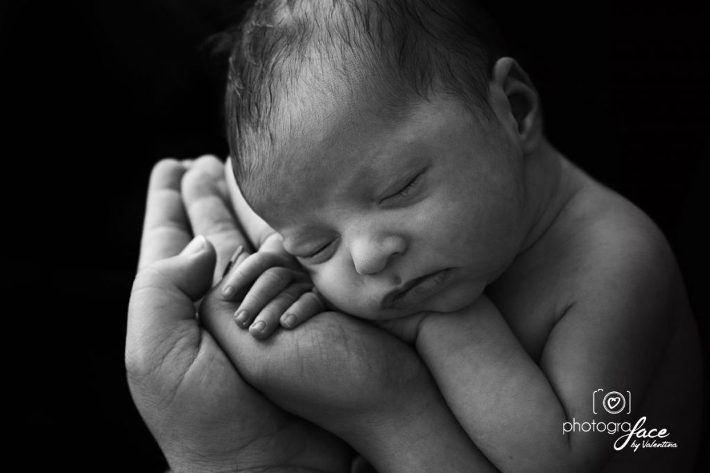 newborn photography: baby sleeping on paretns hands