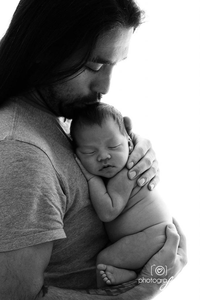 newborn photography: dad kissing baby on the head