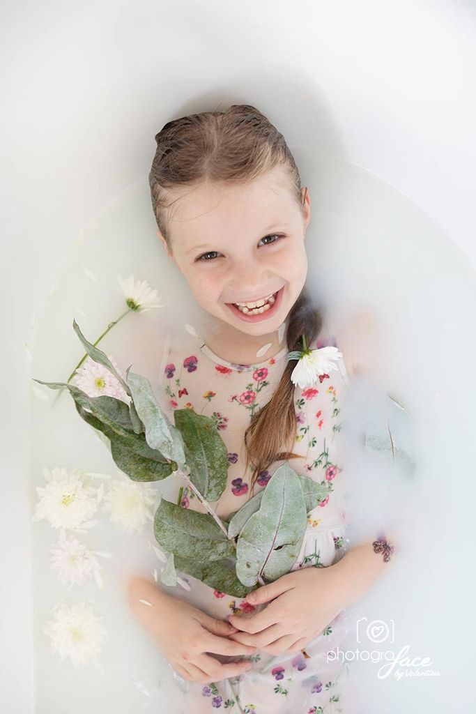 smiling girl in tub with flowers