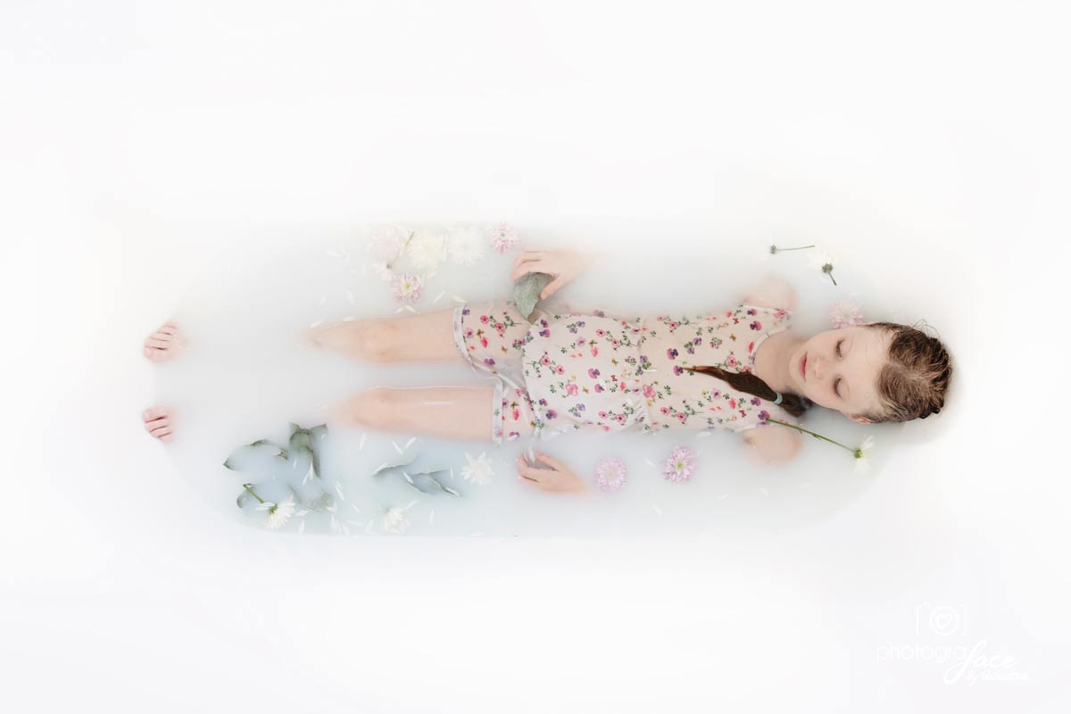 girl in white milk and flowers in a bathtub