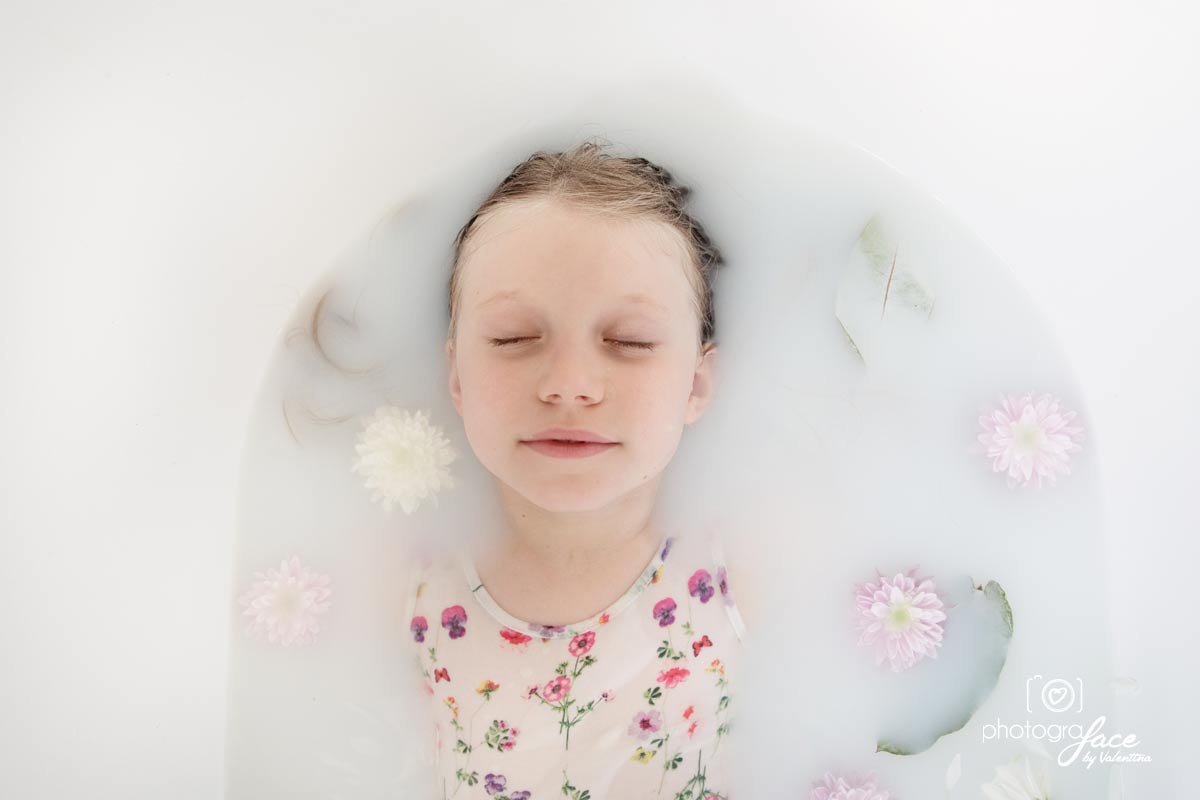 milk bath with flowers, girl with closed eyes