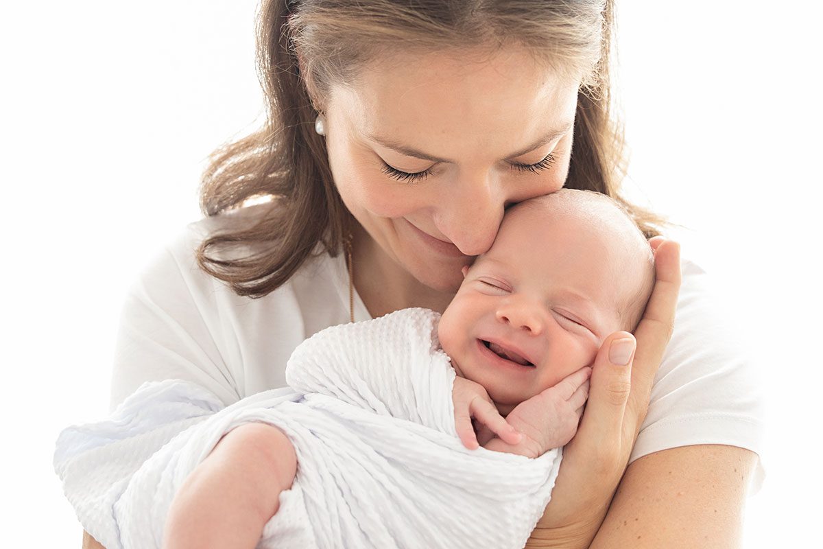 newborn photographer lodon: baby smiling in mum's arms