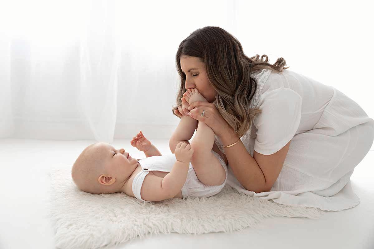 Mum kissing baby's feet during a family session with Valentina, london baby photographer