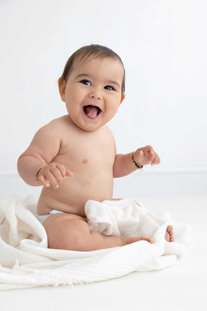 6 month old baby sitting naked during a photoshoot in London