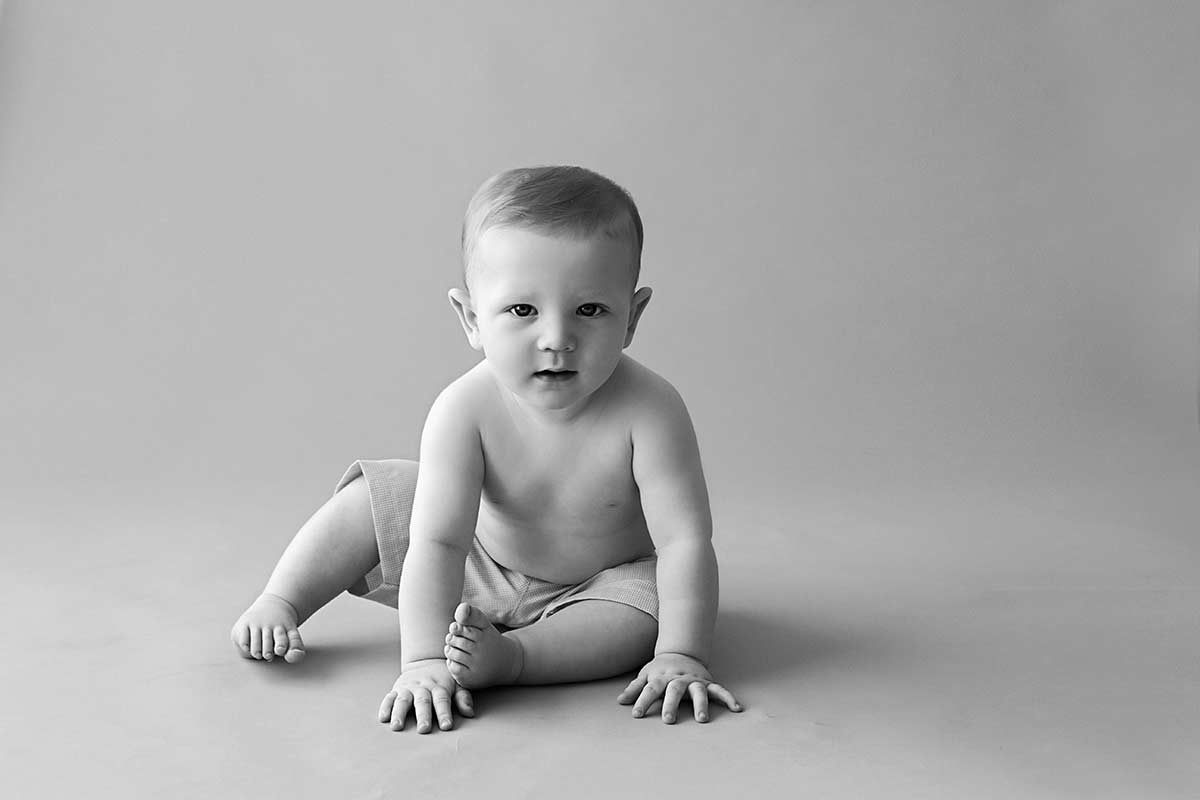 6 month old baby sitting on the floor, black and white image