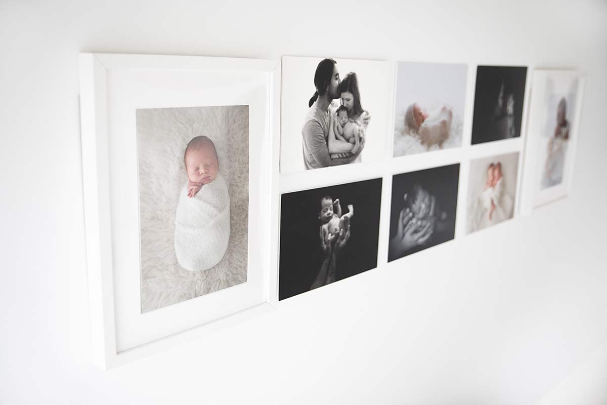 wall with portraits of newborn and babies in the studio of newborn photographer valentina in Richmond London