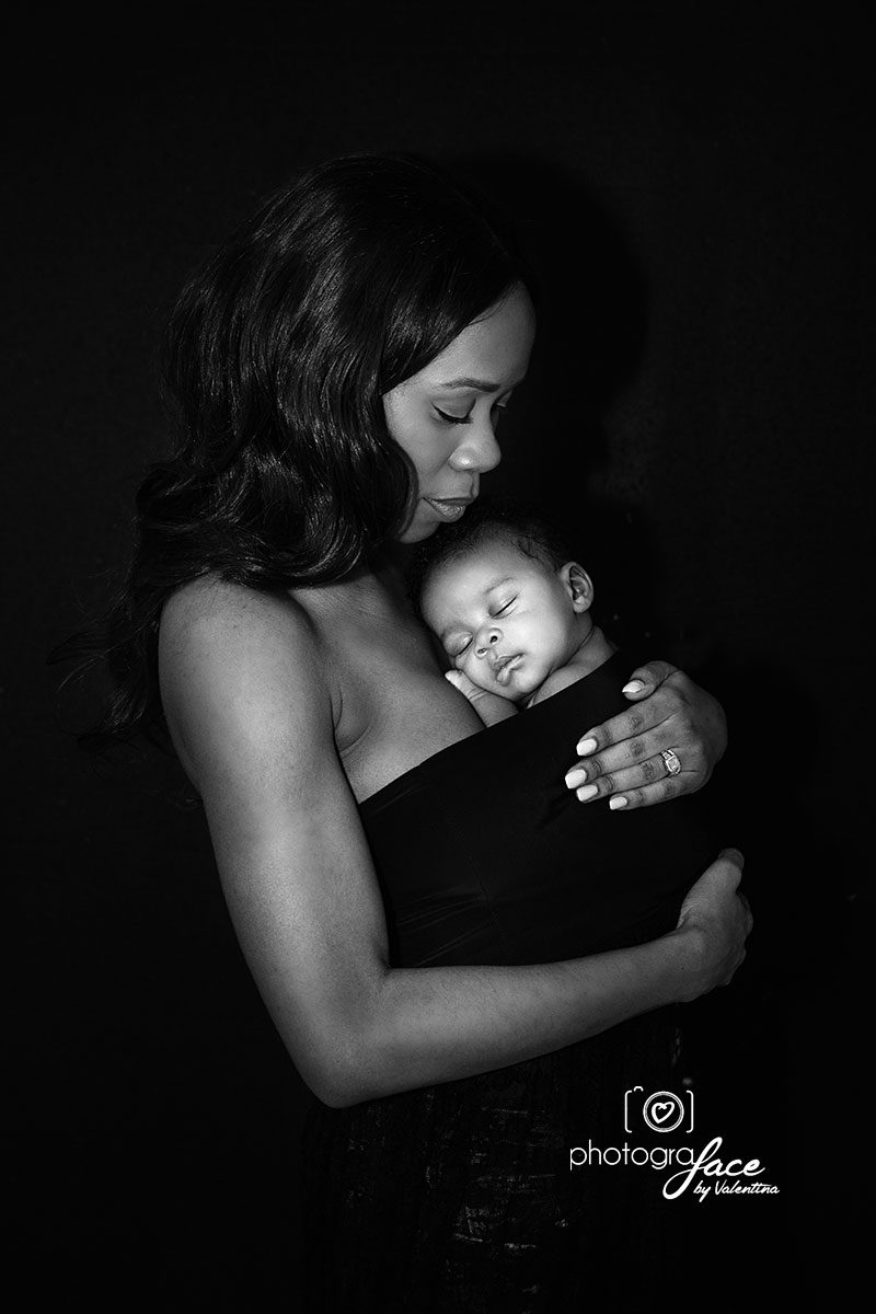 black and white photo of mum holding her newborn baby on her chest.