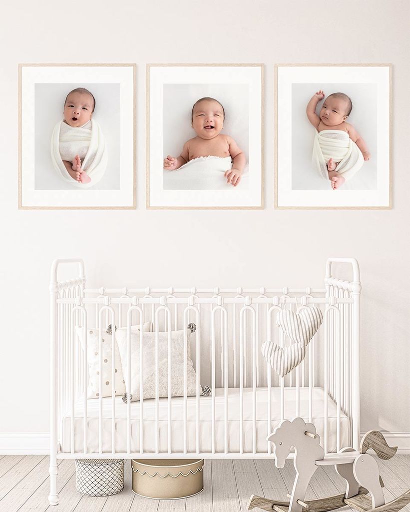 baby nursery idea - baby cot and 3 frames with newborn photos hanging on the wall. 