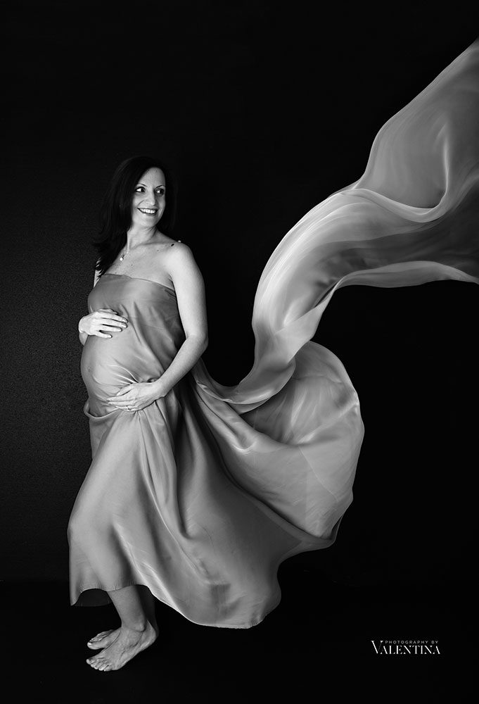 black and white image of maternity. Mum is wearing a floaty piece of fabric
