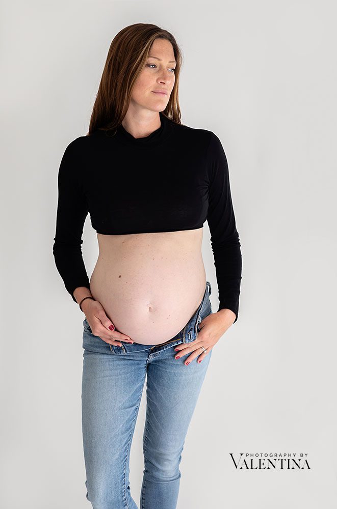 photo of pregnant mum wearing black crop top and jeans