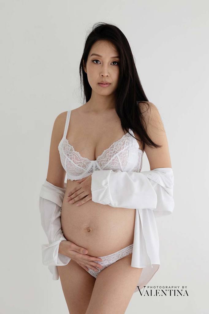 Asian pregnant mum with white lingerie and white short open to reveal the baby belly