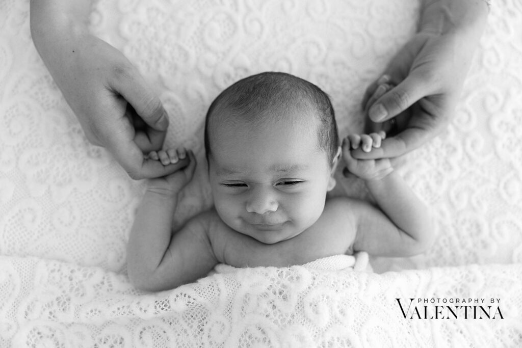 Mum holding newborn hands during a newborn photoshoot with Valentina, London newborn photographer based in Richmond.