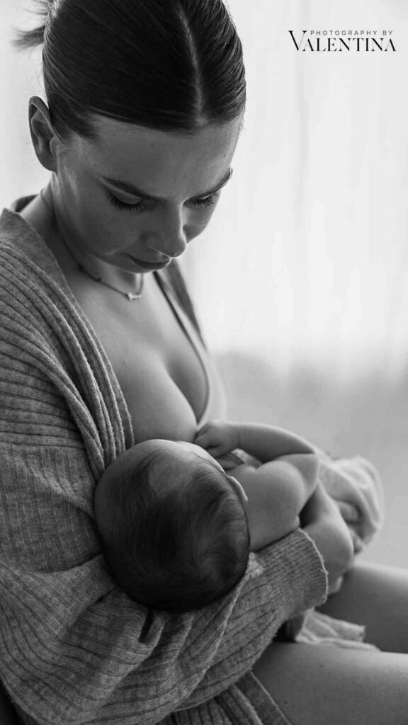 Postpartum recovery and breastfeeding mom with baby. Black and white photo capturing the intimate bond between mother and newborn