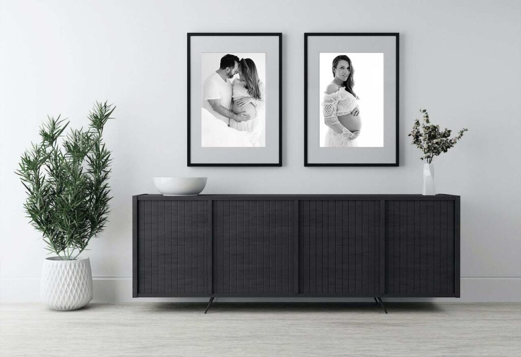 living room wall displaying 2 maternity portraits.