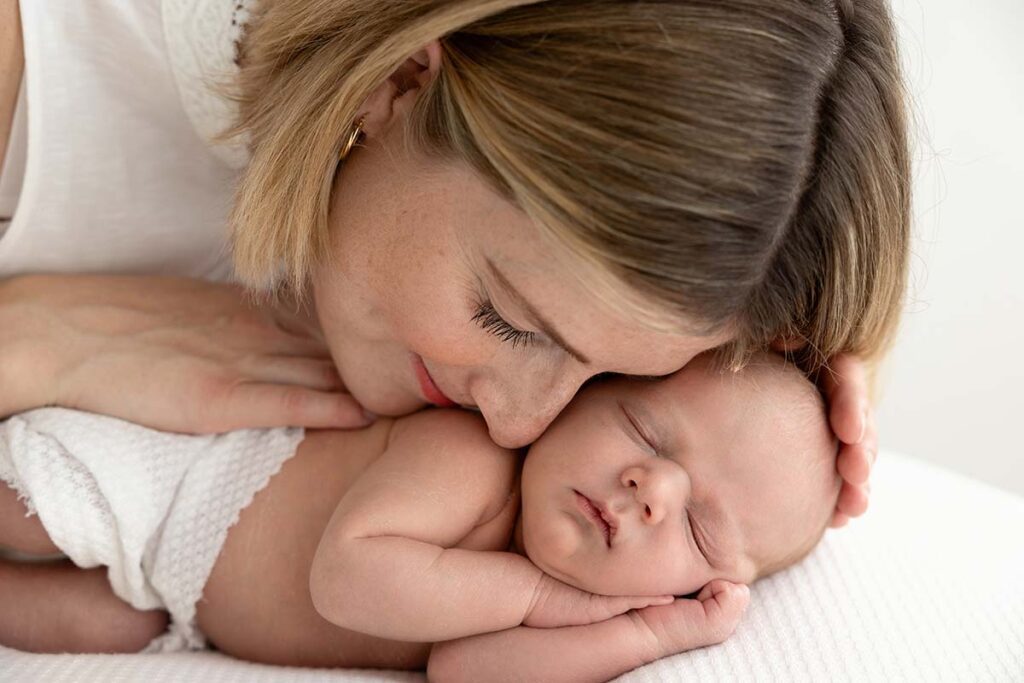 Mum cuddling her newborn baby during a photoshoot with Valentina, London baby photographer